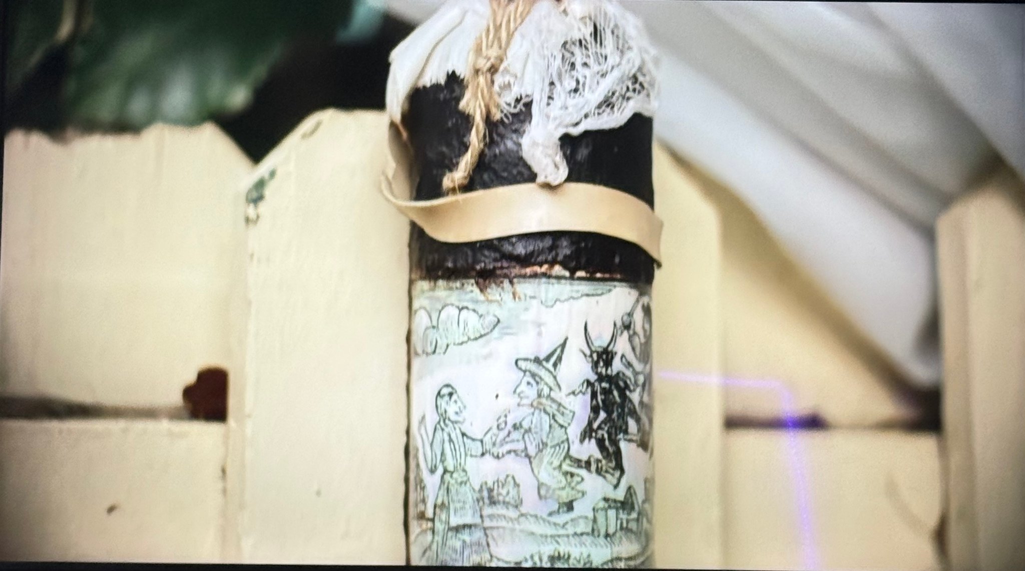 Primitive Witchery spell bottle hanging on a fence in It's Florida Man — Mermaids episode, Season 1